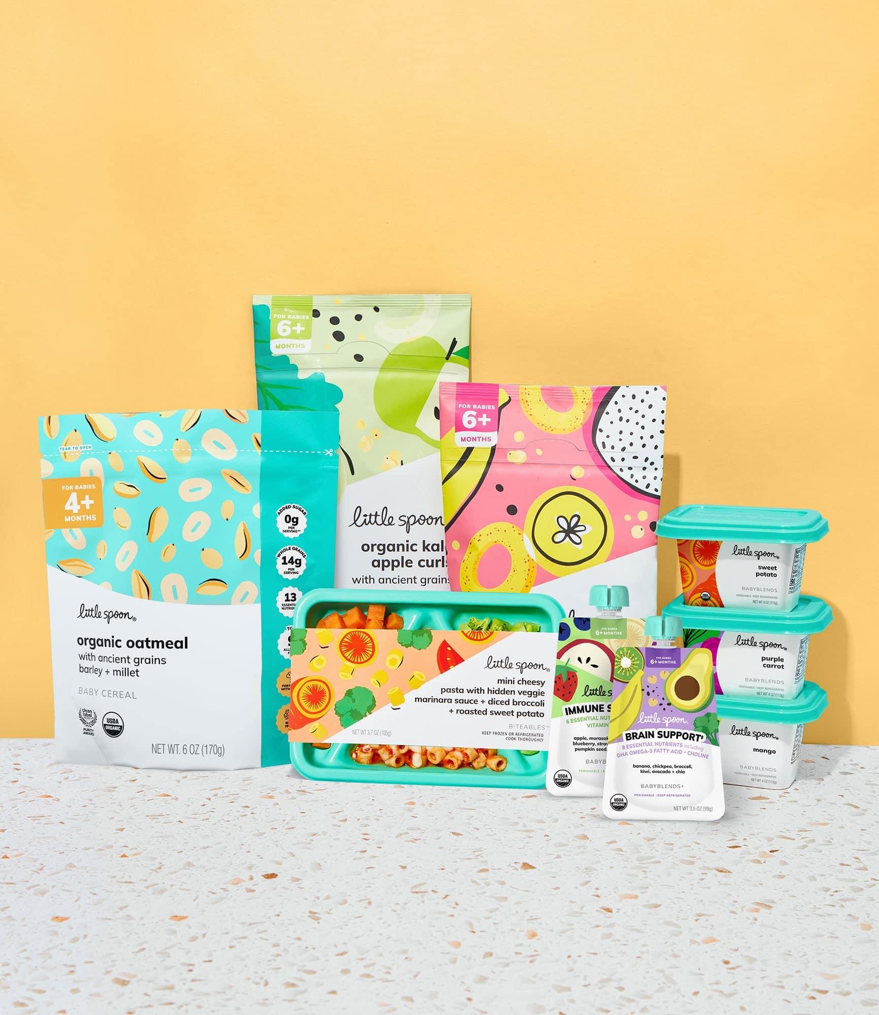 Little Spoon product lineup, including organic oatmeal baby cereal, kale apple curls, banana papaya rings, a Biteables tray, and assorted Babyblends containers, arranged against a yellow background.